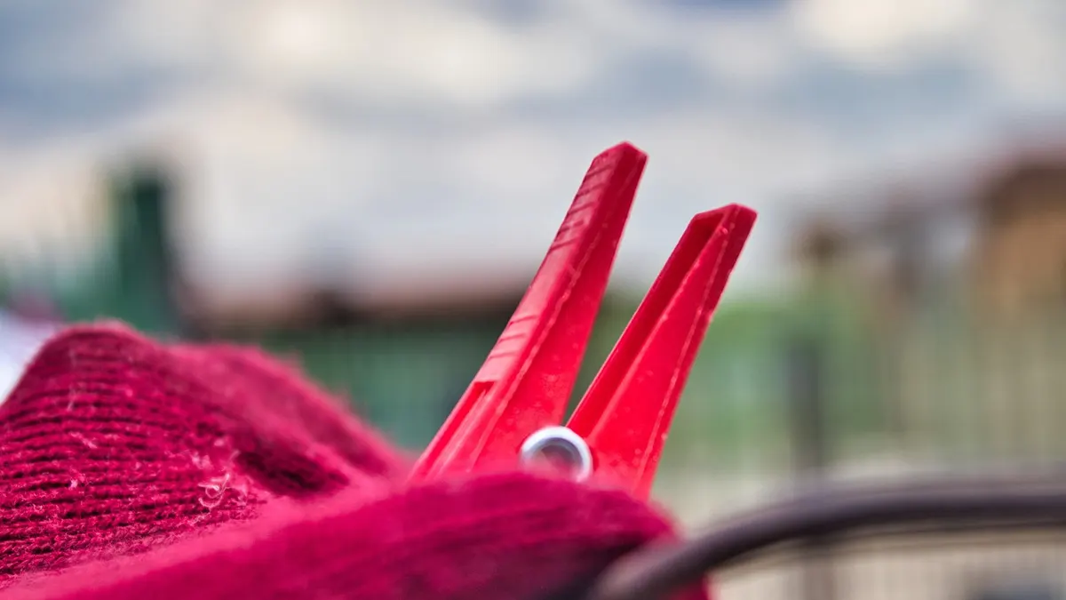 Prendedor vermelho em peça de roupa no varal