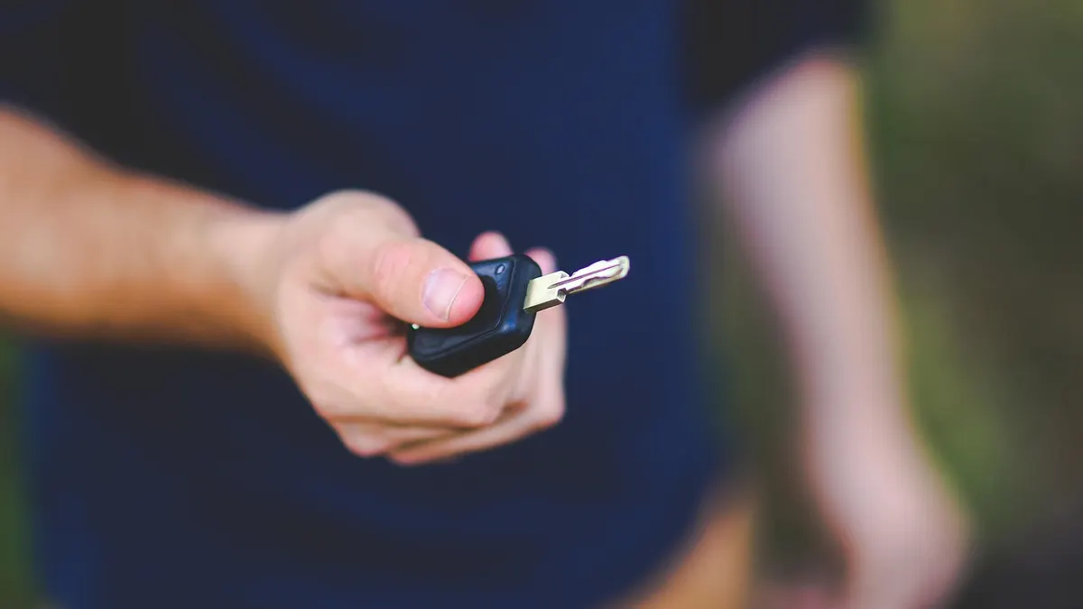 Mão segurando chave de carro com controle