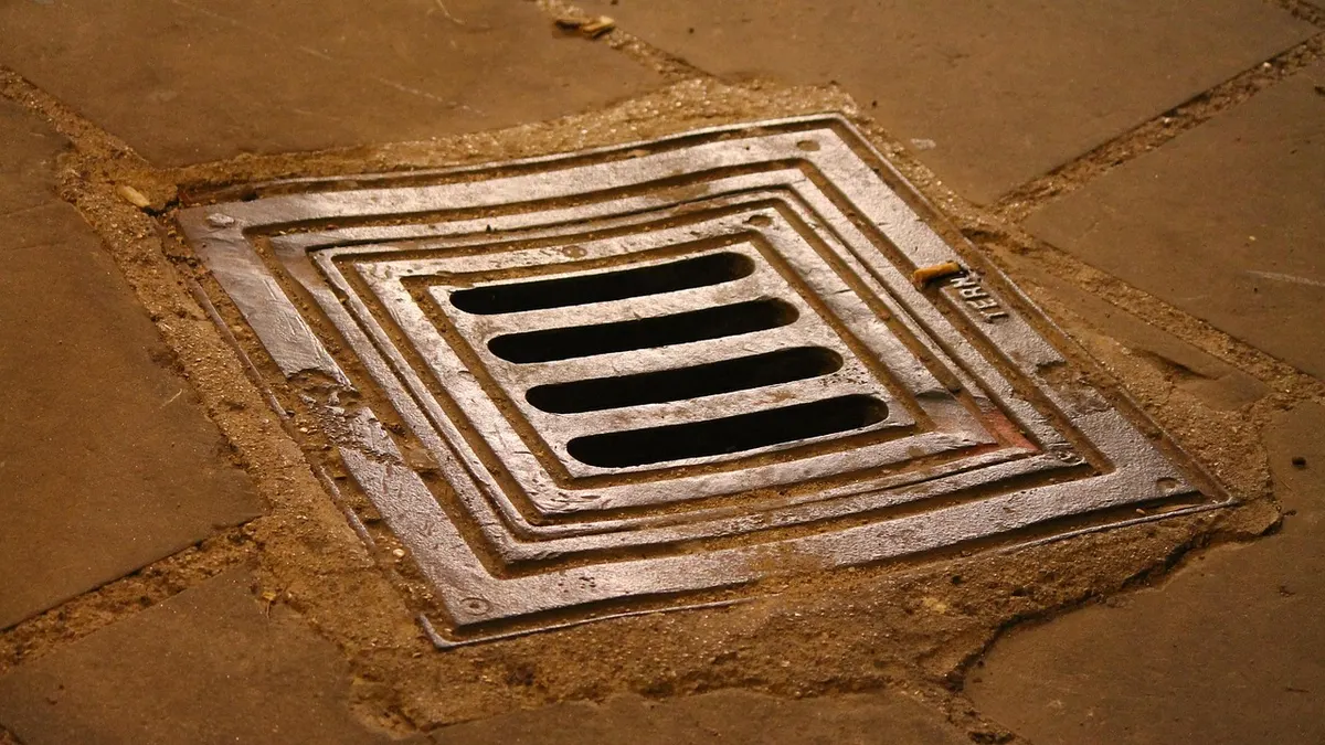 Ralo de piso com grelha metálica em calçada